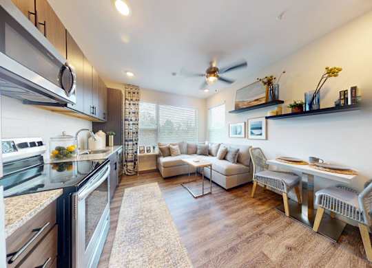 A modern kitchen with a dining area and a ceiling fan.