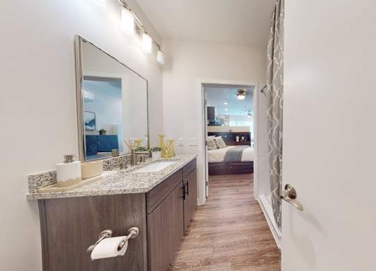 A bathroom with a marble countertop and a large mirror.