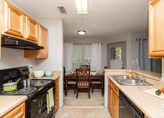 A kitchen with wooden cabinets and a black stove top oven.