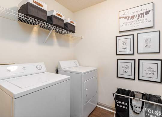 A laundry room with a washer and dryer and a sign that says