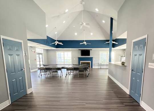 a large room with a table and chairs and a ceiling fan