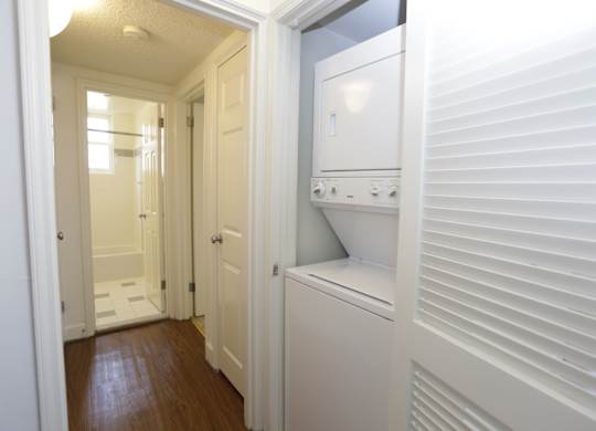 a laundry room with a washer and dryer and a door to a bathroom