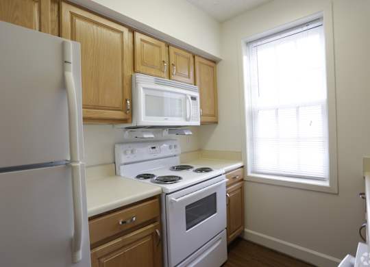a kitchen with white appliances and wooden cabinets