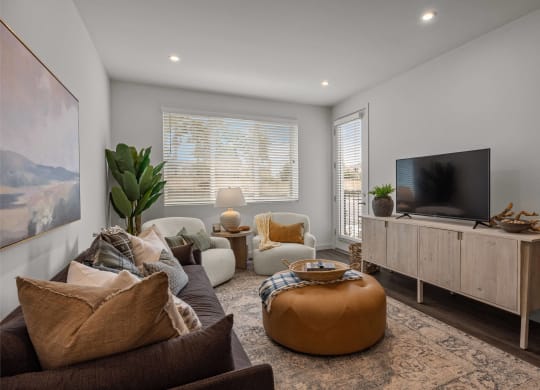 a living room with couches and a tvat Westbury Apartments, California