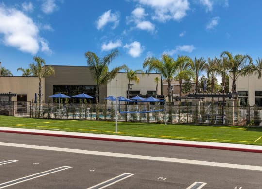 a building with umbrellas and palm trees in front of itat Westbury Apartments, Rancho Cucamonga, CA, 91739