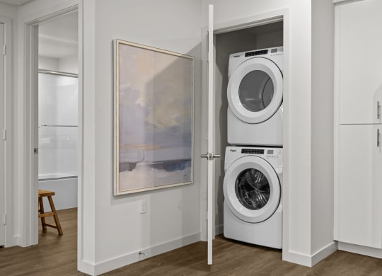 a white washer and dryer in a closet with a doorat Westbury Apartments, Rancho Cucamonga, CA