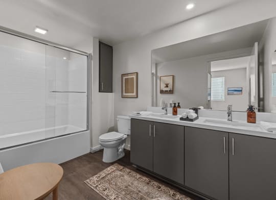 a bathroom with a shower toilet and sink and a mirrorat Westbury Apartments, Rancho Cucamonga, California