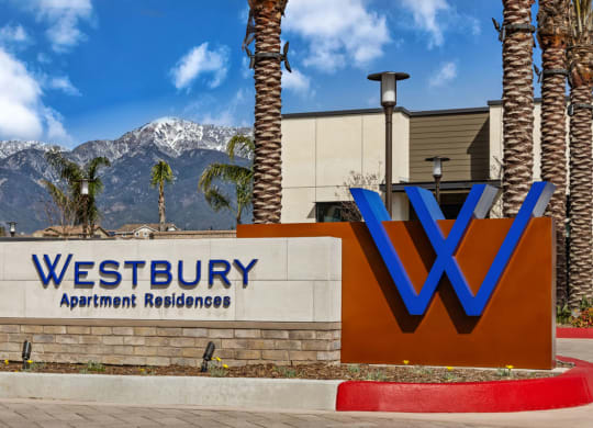 a sign for westbury apartment buildings with mountains in the backgroundat Westbury Apartments, Rancho Cucamonga, CA, 91739