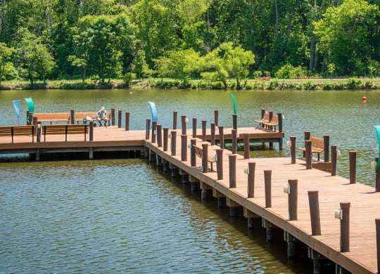 a dock on a lake with chairs on it at The Metropolitan Downtown Columbia, Columbia, Maryland
