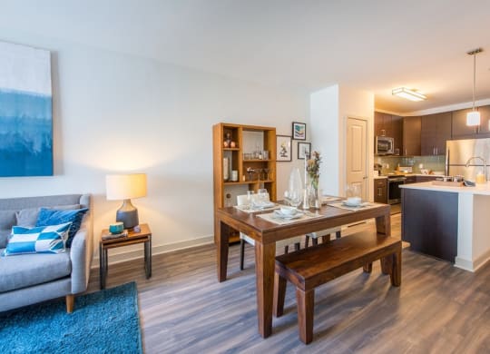 a living room and dining room with a wooden table at The Metropolitan Downtown Columbia, Columbia, 21044