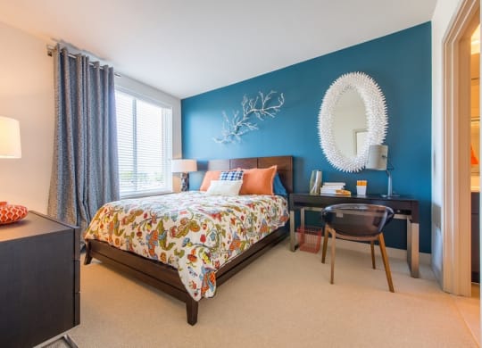 a bedroom with a bed and a desk with a mirror at The Metropolitan Downtown Columbia, Maryland, 21044