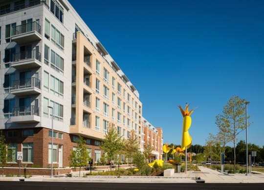 a large yellow sculpture in front of an apartment buildingulpture in front of an apartment buildingulpture in front of an apartment building at The Metropolitan Downtown Columbia, Columbia, MD
