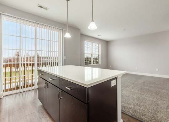 A kitchen with a white countertop and black cabinets.