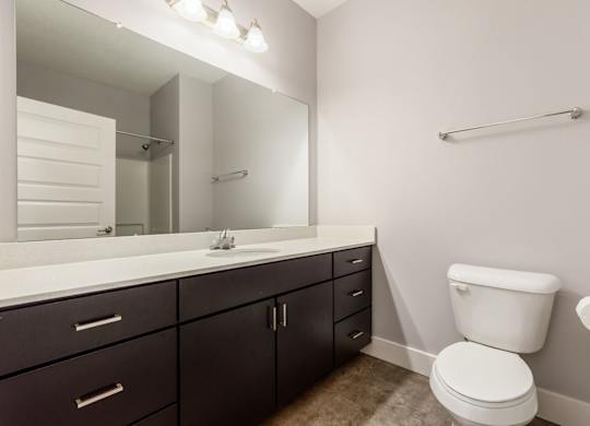 A white toilet sits next to a sink in a bathroom.