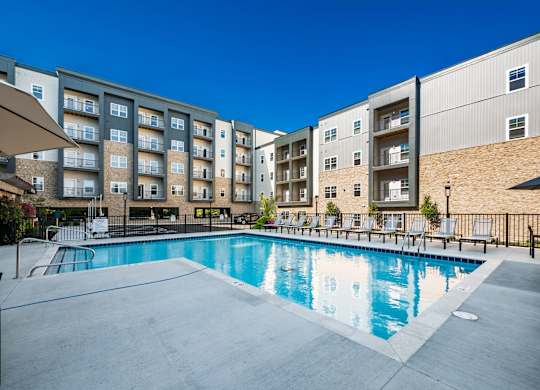 A swimming pool in front of apartment buildings.
