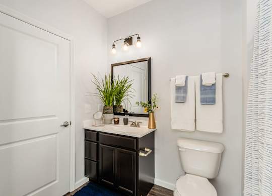 A white toilet sits next to a white sink in a bathroom.