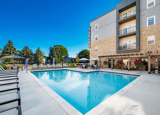 A large swimming pool in front of a building with a sign that reads