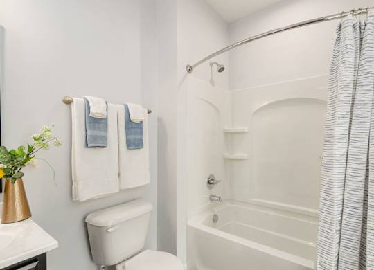 A white bathroom with a toilet, sink, and bathtub.