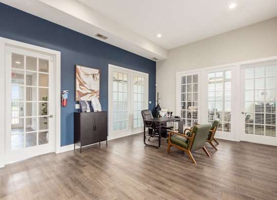 A room with a desk and chairs in it.