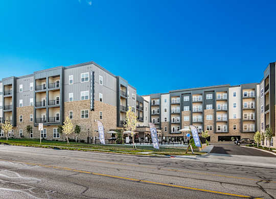A large apartment complex with a parking lot in front.