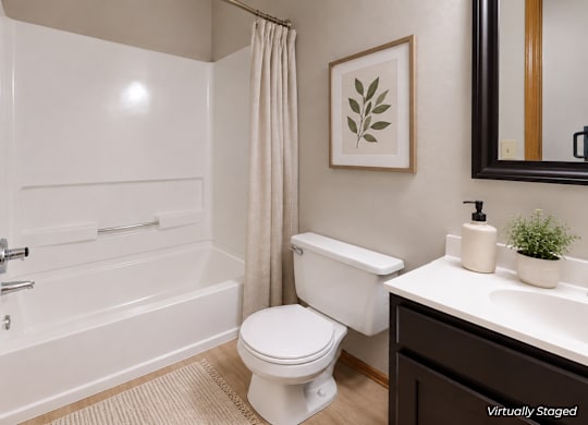 A white bathroom with a toilet, sink, and bathtub.