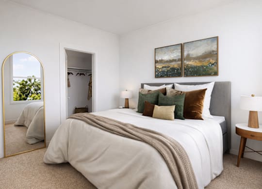 A bedroom with a large bed and a painting on the wall.