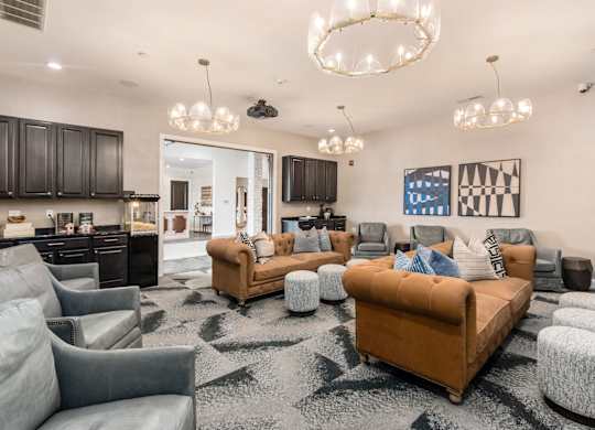 A living room with a brown sofa and grey armchairs.