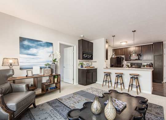 A modern living room with a bar area and a kitchen in the background.