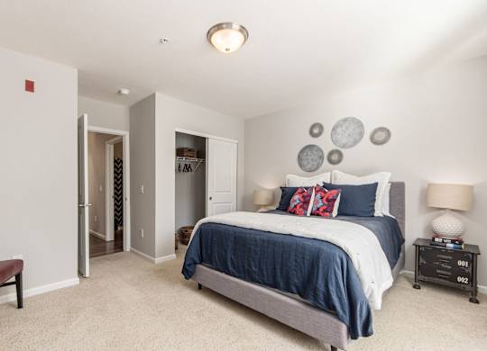A bedroom with a bed, nightstands, and a chair.