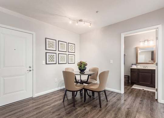 A dining room with a table and chairs.