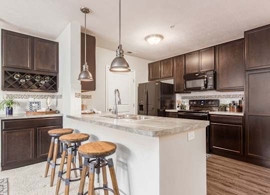 A kitchen with a white countertop and dark brown cabinets.