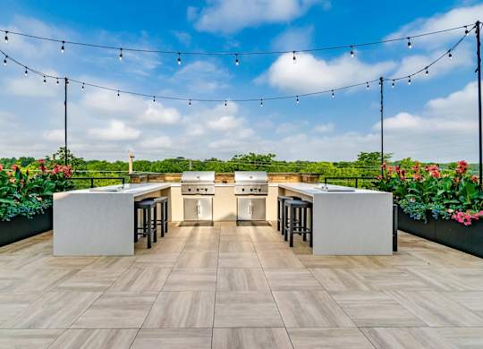 A modern outdoor kitchen with a bar area and seating.
