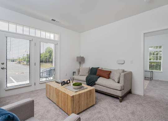 A living room with a grey couch and a wooden coffee table.