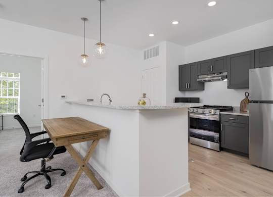 A kitchen with a white island and a black chair.