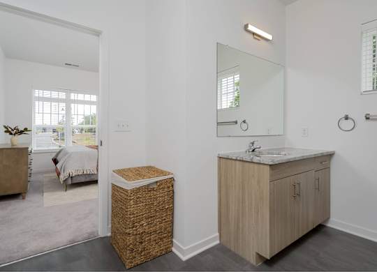A bathroom with a wooden vanity and a mirror above it.