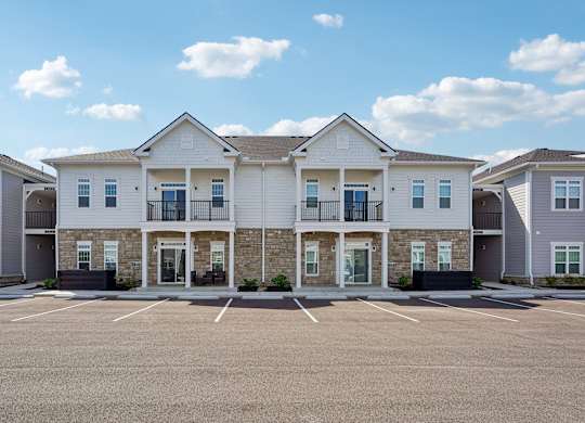 A row of houses with a parking lot in front.