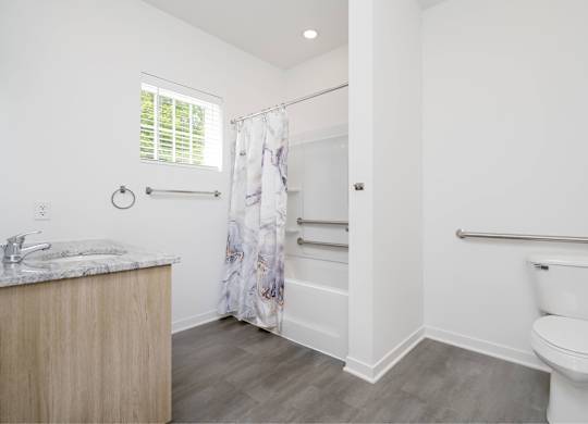 A bathroom with a toilet, sink, and shower.