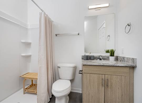 A white bathroom with a toilet, sink, and a mirror.