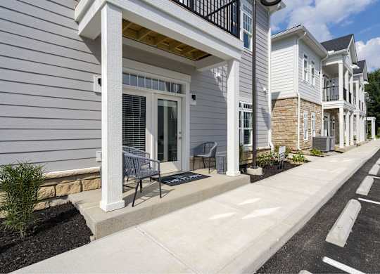 A row of houses with white siding and black railings.