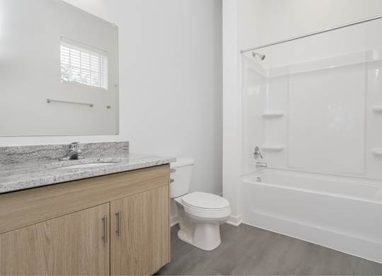 A white bathroom with a toilet, sink, and bathtub.