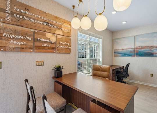 A wooden desk with a sign that says "To deliver the best investment and living experience ever" is in the foreground of the image.