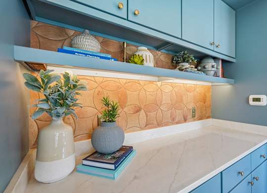A kitchen counter with a vase and books on it.