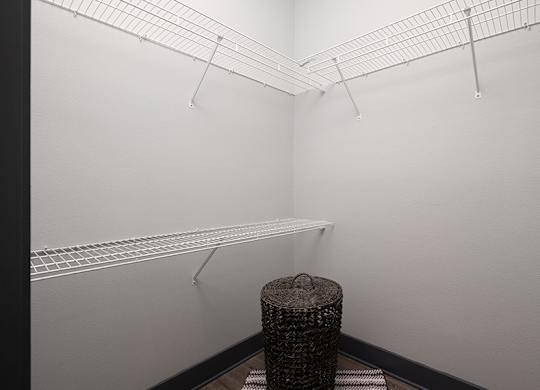 A room with a white wall and a black trash can.