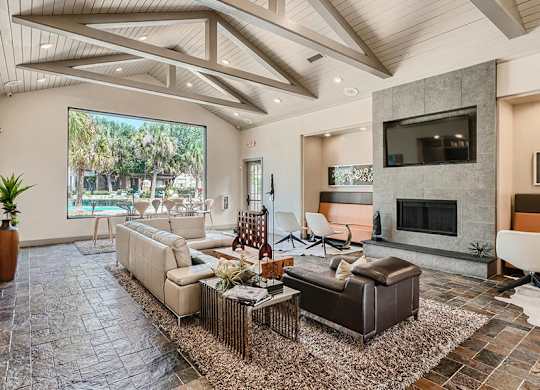 A living room with a stone floor and a large window.