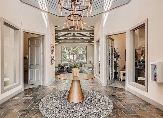 A modern interior with a large table and a chandelier.