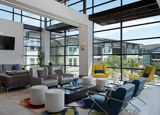 A modern living room with a large window and a flat screen TV mounted on the wall.