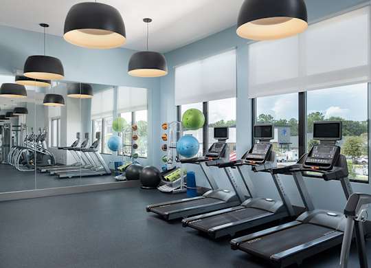 A gym with treadmills, exercise balls, and other equipment.