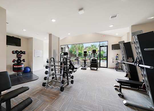 A gym with a variety of equipment including weights and machines.
