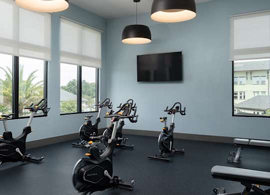A gym with exercise bikes and a television.