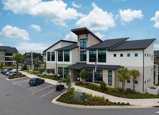 A modern building with a parking lot in front.